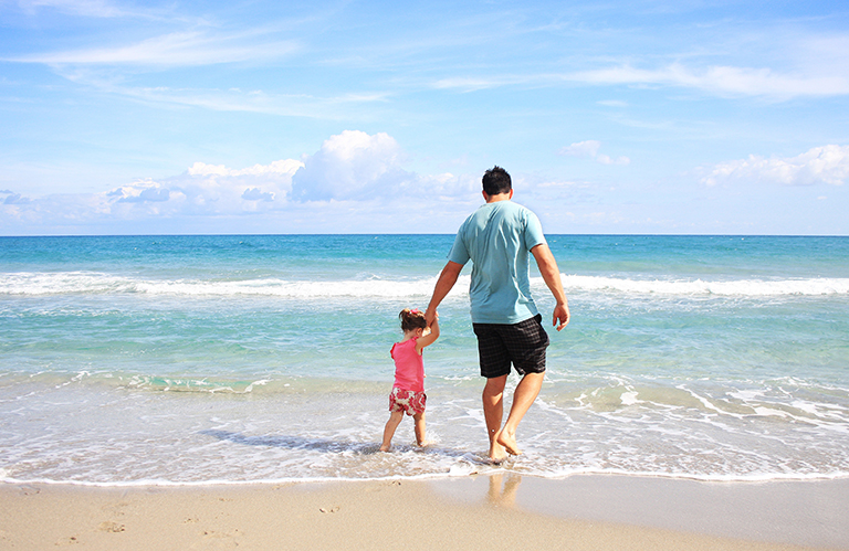 Padre e hija en la playa. Mantener la playa limpia